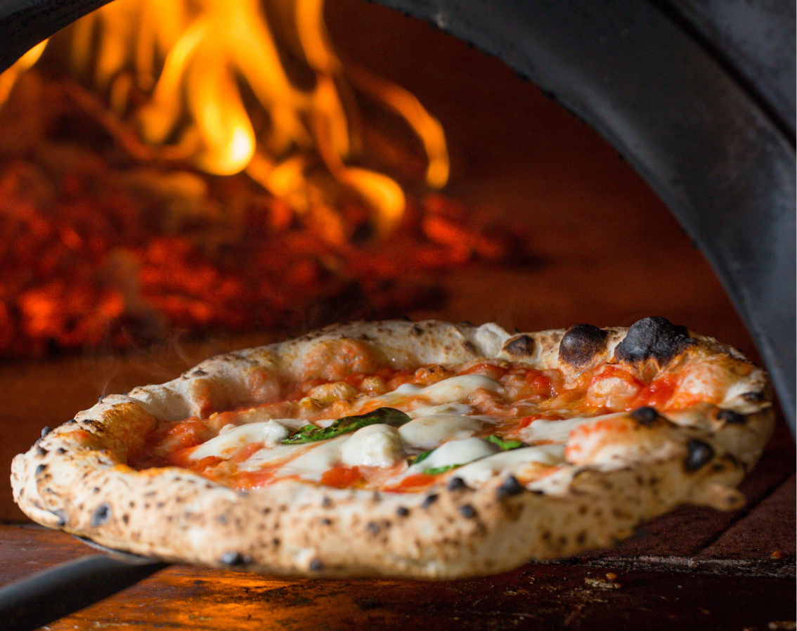 Neapolitan-style pizza baking in mobile wood-fired pizza oven